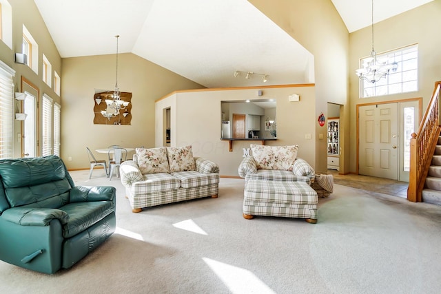 carpeted living room with an inviting chandelier, plenty of natural light, and high vaulted ceiling