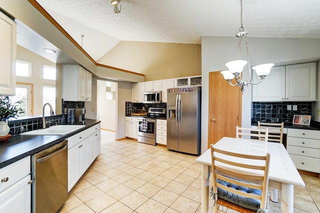 kitchen featuring sink, light tile patterned floors, pendant lighting, stainless steel appliances, and white cabinets