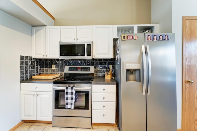 kitchen featuring backsplash, stainless steel appliances, white cabinets, and light tile patterned flooring