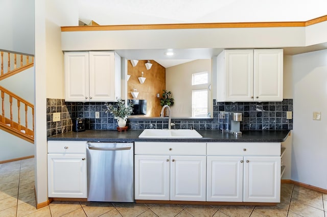 kitchen featuring sink, tasteful backsplash, vaulted ceiling, stainless steel dishwasher, and white cabinets