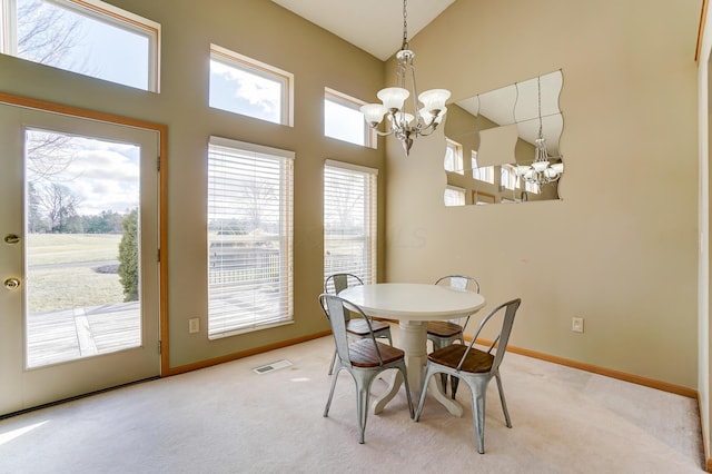 dining room featuring high vaulted ceiling, carpet floors, and a chandelier