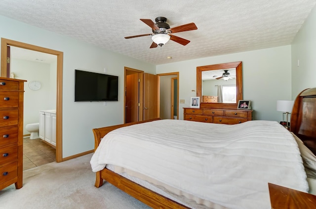 carpeted bedroom featuring ceiling fan, connected bathroom, and a textured ceiling