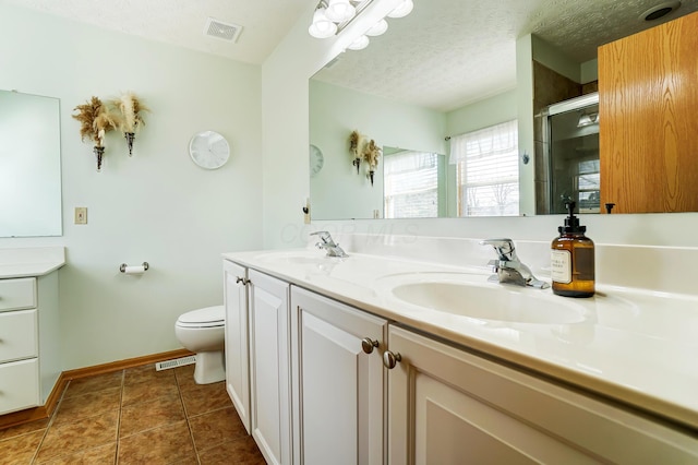 bathroom with walk in shower, toilet, a textured ceiling, vanity, and tile patterned flooring