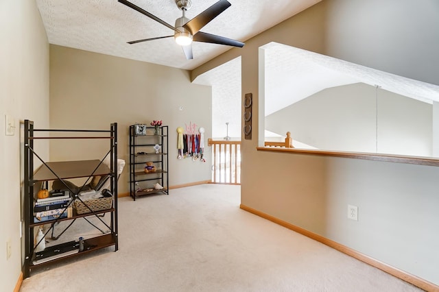 interior space with ceiling fan, lofted ceiling, and a textured ceiling