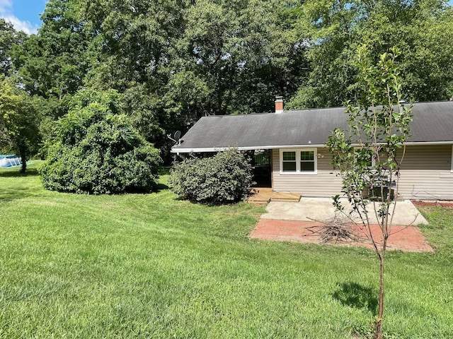 rear view of house featuring a patio area and a lawn