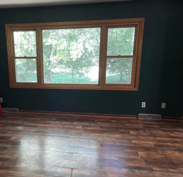 unfurnished room with dark wood-type flooring