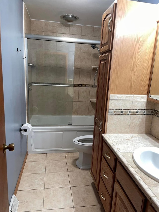 full bathroom featuring tile patterned floors, toilet, combined bath / shower with glass door, vanity, and backsplash