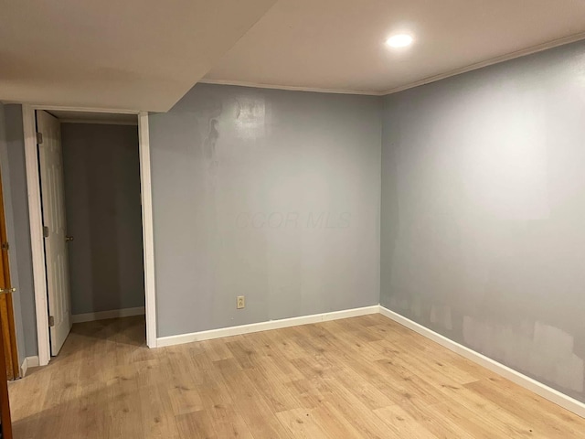 empty room featuring crown molding and light hardwood / wood-style floors