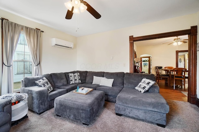 living room with an AC wall unit and ceiling fan