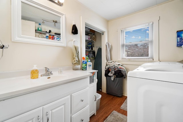 laundry room with sink, washing machine and dryer, and dark hardwood / wood-style floors