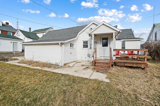 bungalow-style home with a wooden deck and a front yard