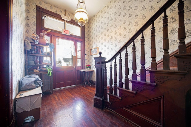 entrance foyer featuring stairs, wood-type flooring, and wallpapered walls