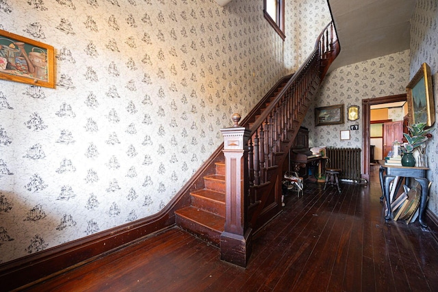 stairway featuring hardwood / wood-style flooring and wallpapered walls