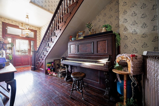 entryway featuring wallpapered walls, stairs, and dark wood-style flooring