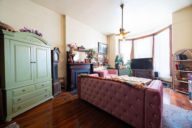 living room with a fireplace, visible vents, and dark wood-type flooring