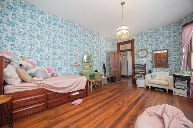 bedroom with a chandelier, wood finished floors, and wallpapered walls