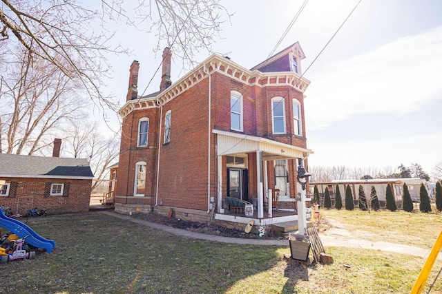 exterior space with a porch, brick siding, a playground, and a chimney