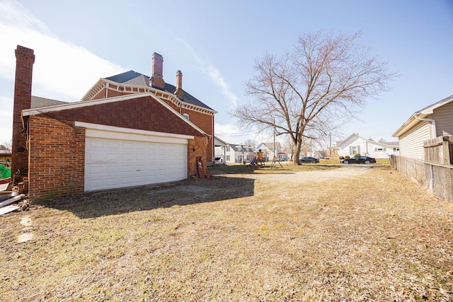 view of side of home with a chimney, a residential view, fence, and brick siding