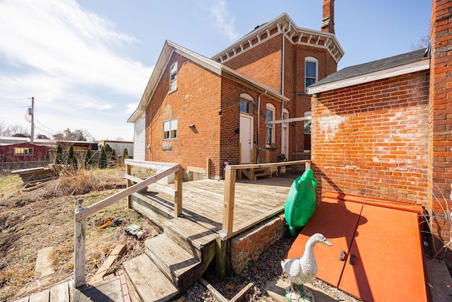 view of side of property with brick siding and a wooden deck