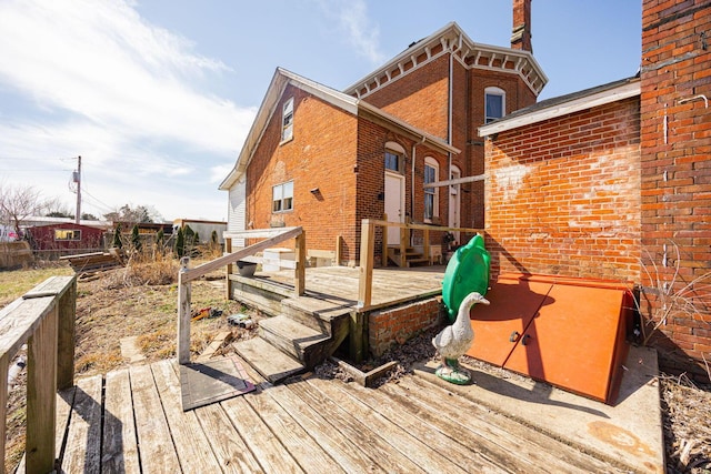 exterior space with brick siding and a wooden deck