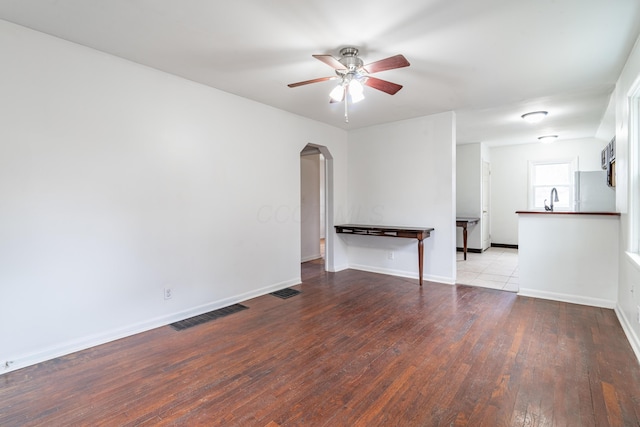 empty room with vaulted ceiling, ceiling fan, sink, and light wood-type flooring