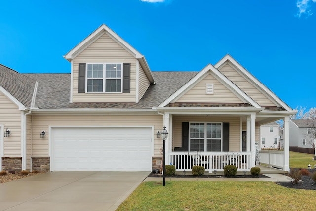 craftsman-style home with a garage, covered porch, and a front lawn