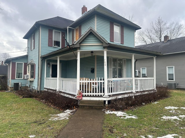 country-style home with a porch, central AC, a front yard, and cooling unit