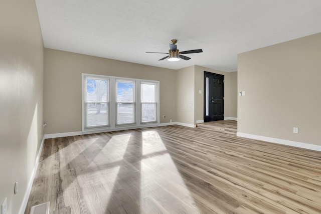 spare room with ceiling fan and light wood-type flooring