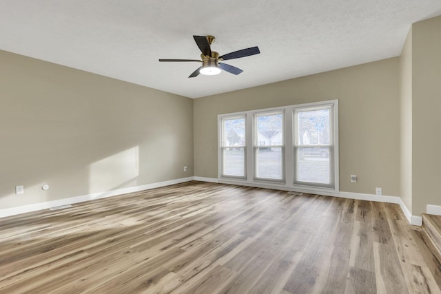 unfurnished room featuring ceiling fan, light hardwood / wood-style flooring, and a textured ceiling