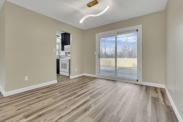 unfurnished living room featuring sink and light wood-type flooring