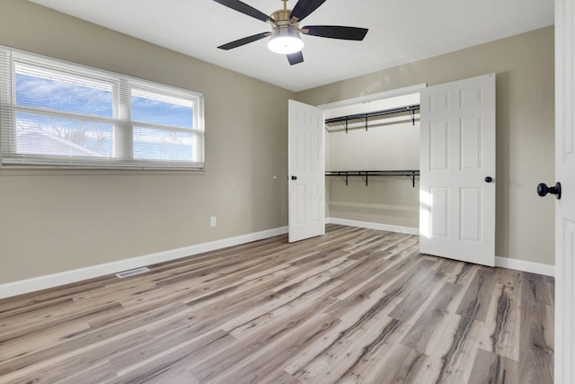 unfurnished bedroom featuring ceiling fan, a closet, and light wood-type flooring