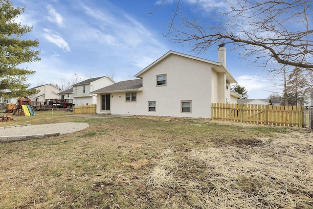 rear view of property featuring a yard and a playground