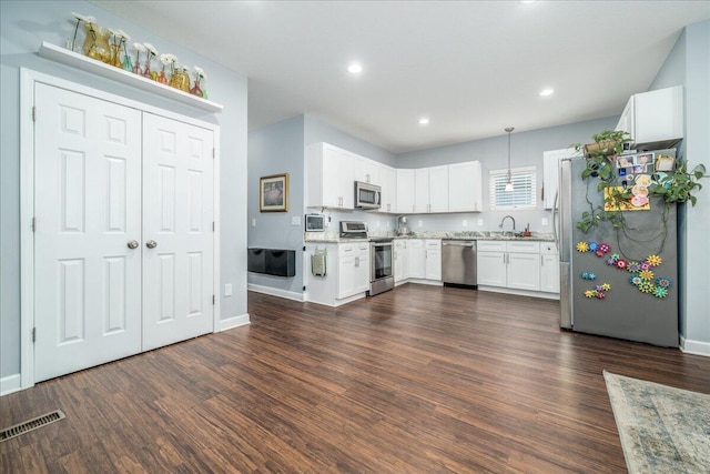 kitchen featuring dark wood-style floors, appliances with stainless steel finishes, visible vents, and white cabinets