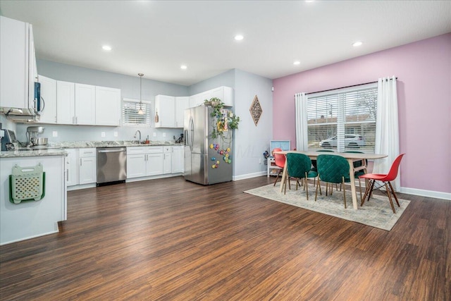 kitchen with dark hardwood / wood-style floors, sink, white cabinets, hanging light fixtures, and stainless steel appliances