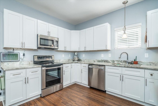 kitchen with white cabinetry, sink, decorative light fixtures, and stainless steel appliances