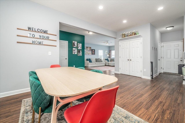 dining room featuring a textured ceiling, wood finished floors, and baseboards