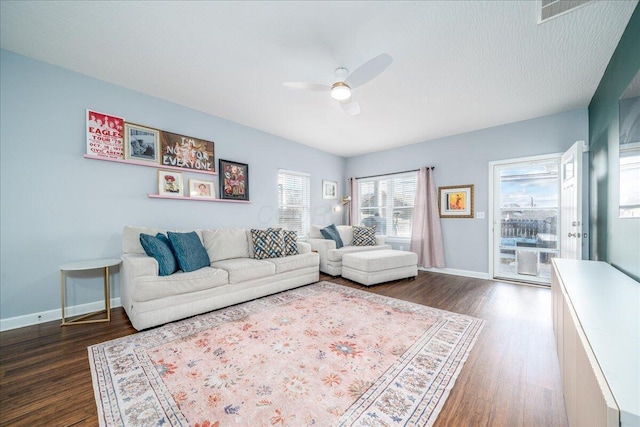 living area featuring dark wood-style floors, ceiling fan, and baseboards