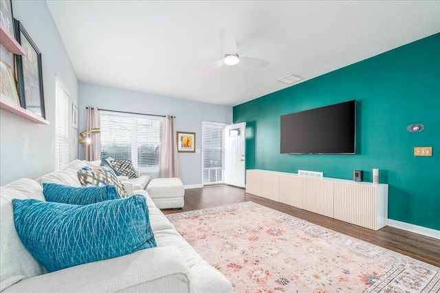 living room with ceiling fan, dark hardwood / wood-style floors, and a textured ceiling