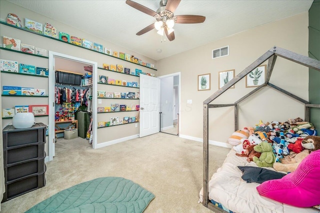 bedroom with baseboards, visible vents, carpet, a walk in closet, and a closet