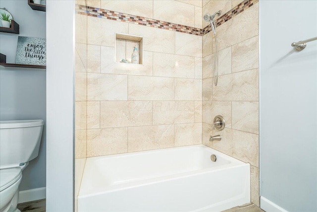 bathroom featuring toilet and tiled shower / bath combo