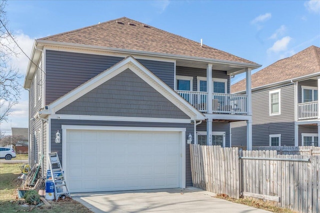 view of front of home featuring driveway, a shingled roof, fence, and an attached garage