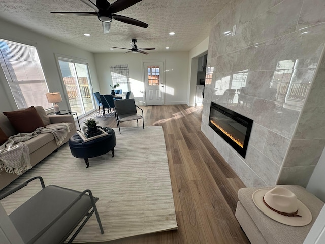 living room with wood-type flooring, a fireplace, and a textured ceiling