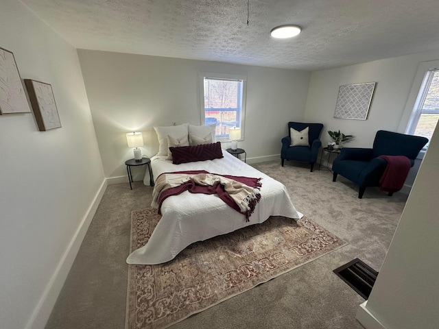 bedroom featuring multiple windows, a textured ceiling, and carpet