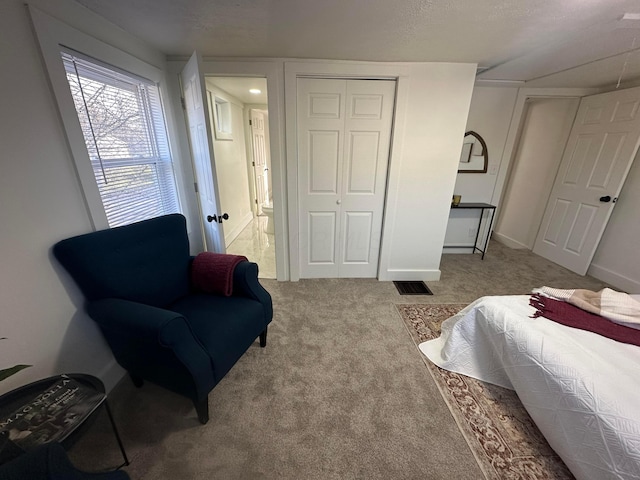 bedroom featuring light carpet and a closet