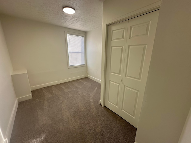 unfurnished bedroom with a closet, carpet floors, and a textured ceiling