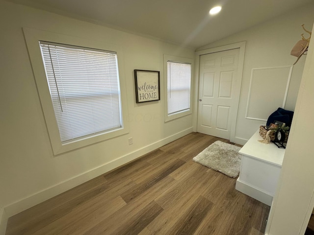 unfurnished bedroom with lofted ceiling and wood-type flooring