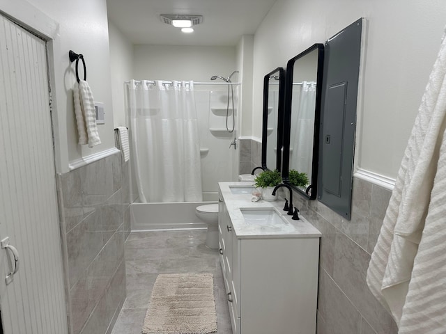 full bathroom featuring vanity, toilet, tile walls, and shower / bath combo