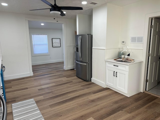 kitchen featuring stainless steel fridge with ice dispenser, a textured ceiling, dark hardwood / wood-style floors, and white cabinets