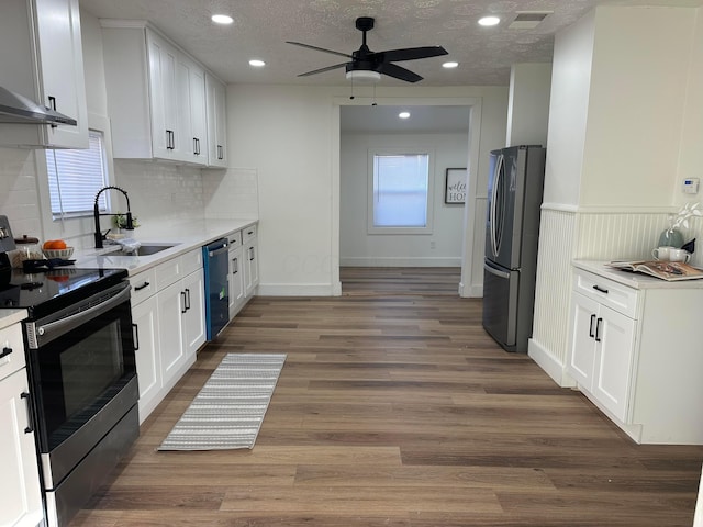 kitchen with sink, a textured ceiling, stainless steel appliances, and white cabinets