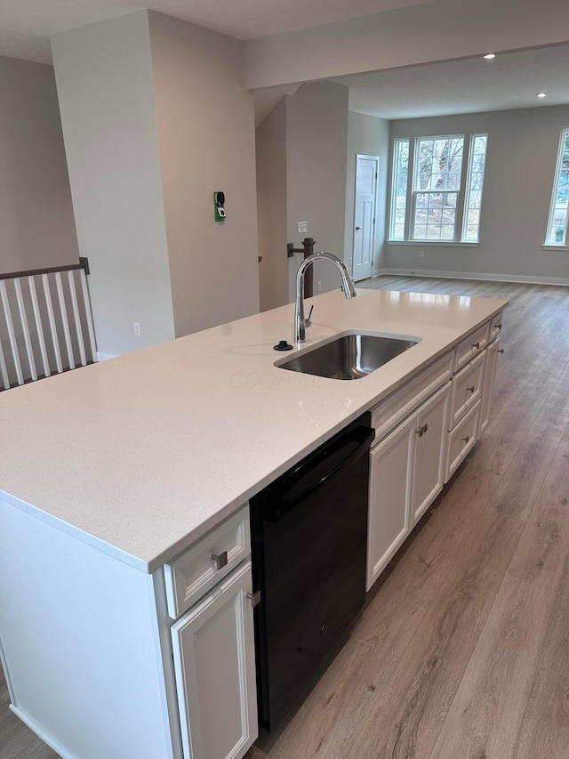 kitchen featuring sink, a center island with sink, dishwasher, light hardwood / wood-style floors, and white cabinets